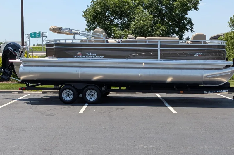 Slide: The Image of 2025 Sun Tracker Sportfish 24 XP3 pontoon boat on trailer in parking lot. - 59