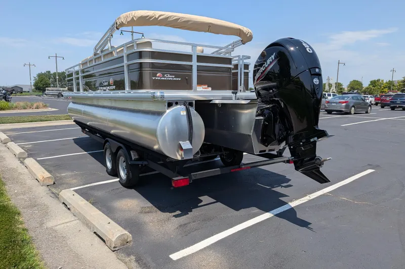 Slide: The Image of 2025 Sun Tracker Sportfish 24 XP3 pontoon boat with Mercury outboard motor in parking lot. - 68