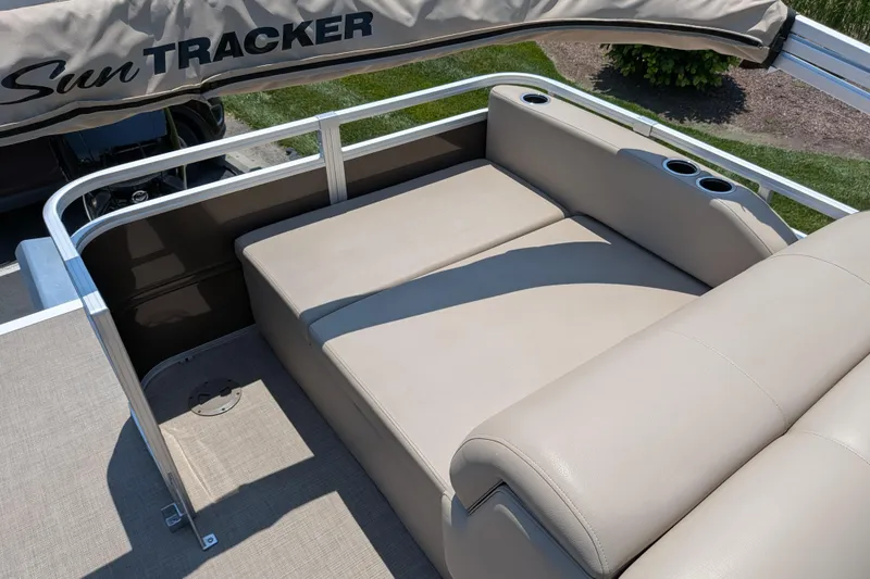 Slide: The Image of 2025 Sun Tracker Sportfish 24 XP3 boat with beige seating and cup holders. - 65