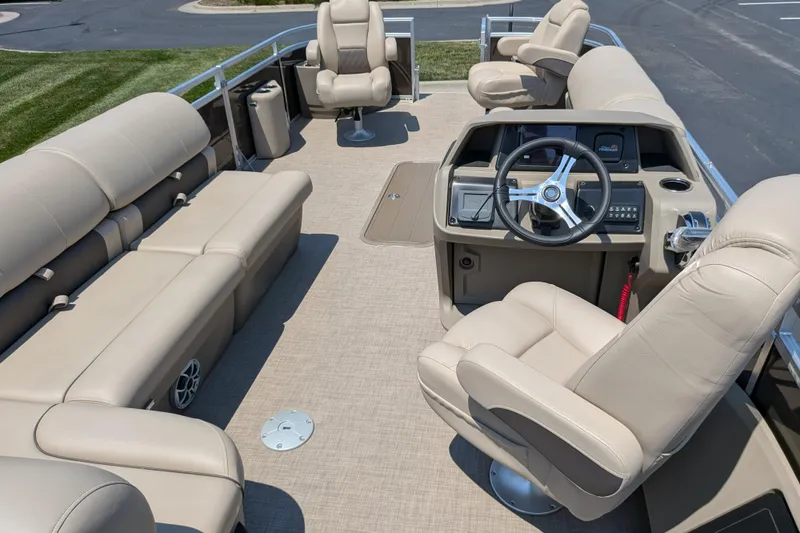 Slide: The Image of 2025 Sun Tracker Sportfish 24 XP3 pontoon boat interior with beige seating and steering console. - 63