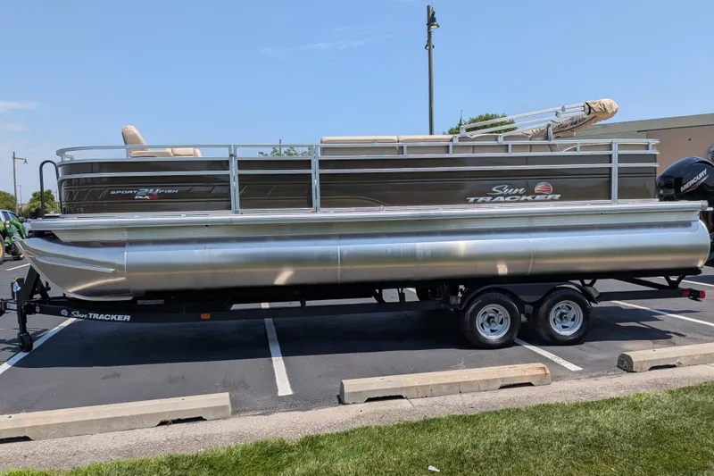 Slide: The Image of 2025 Sun Tracker Sportfish 24 XP3 pontoon boat on trailer in parking lot. - 69