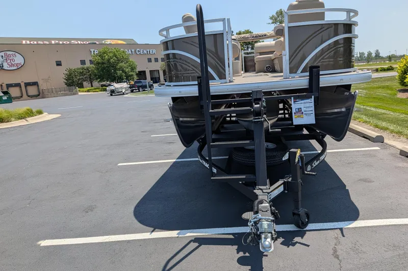 Slide: The Image of 2025 Sun Tracker Sportfish 24 XP3 pontoon boat on trailer at Bass Pro Shops parking lot. - 70