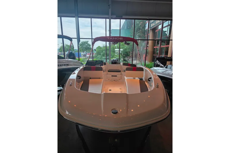 Slide: The Image of 2026 Tahoe T18 boat displayed indoors with seating and canopy. - 1