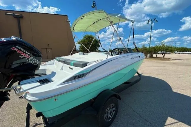 Slide: The Image of 2026 Tahoe T18 boat with canopy on trailer, parked outdoors under blue sky. - 3