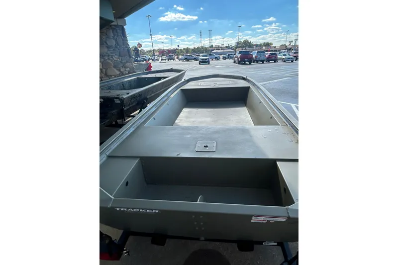 Slide: The Image of 2026 Tracker Grizzly 1648 Utility boat in parking lot under clear sky. - 2