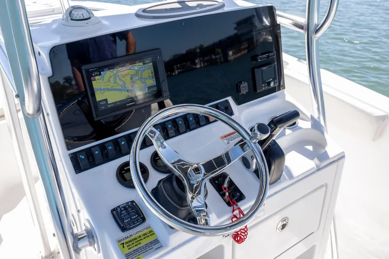 Slide: The Image of 2020 Sea Hunt Triton 210 boat console with steering wheel and navigation system. - 10