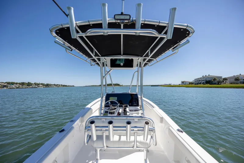 Slide: The Image of 2020 Sea Hunt Triton 210 boat on calm water under clear blue sky. - 16