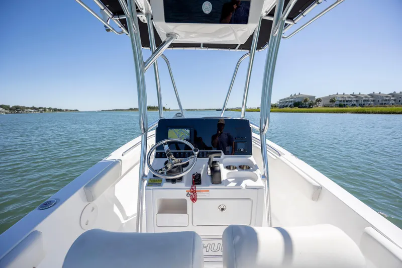 Slide: The Image of 2020 Sea Hunt Triton 210 boat on calm water, featuring a modern helm and clear sky. - 17