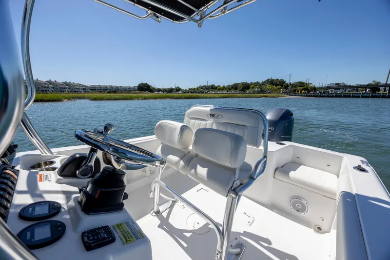 Slide: The Image of 2020 Sea Hunt Triton 210 boat interior with steering console on a sunny day. - 19