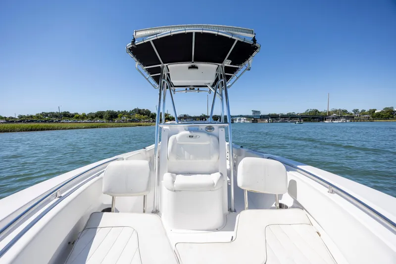 Slide: The Image of 2020 Sea Hunt Triton 210 boat on calm water, featuring a sleek design and spacious seating. - 23