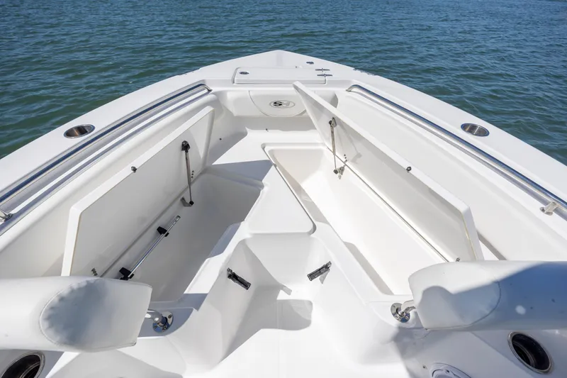 Slide: The Image of 2020 Sea Hunt Triton 210 boat interior with open storage compartments on calm water. - 25
