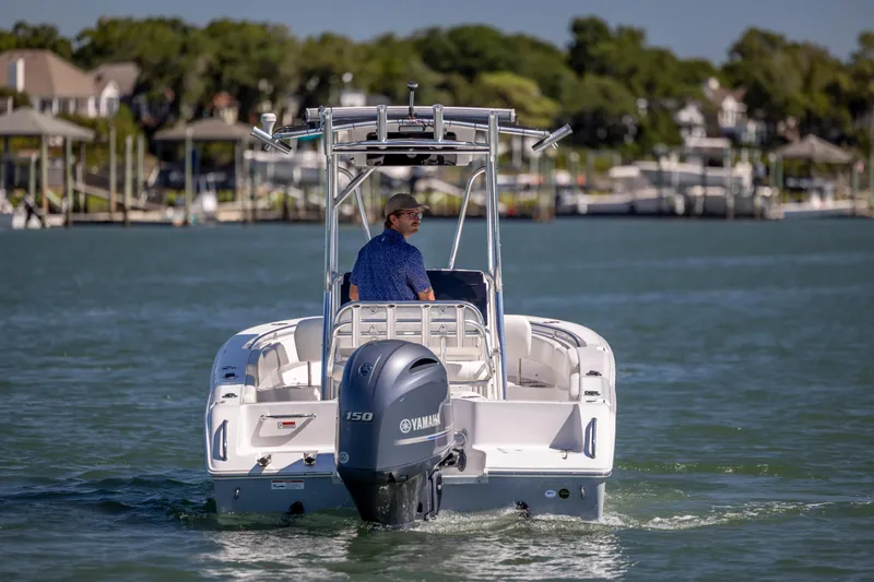 Slide: The Image of 2020 Sea Hunt Triton 210 boat cruising on a calm waterway with a Yamaha engine. - 6