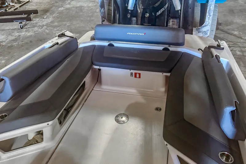 Slide: The Image of 2023 Axopar 25 Cross Top boat interior with cushioned seating and Mercury engine. - 10