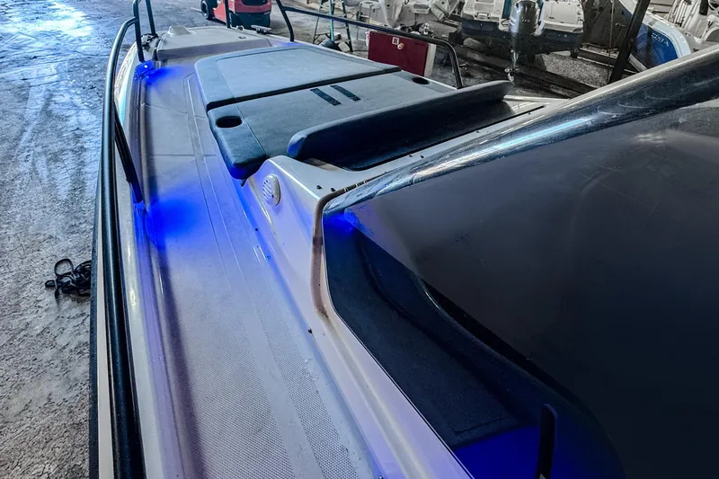 Slide: The Image of 2023 Axopar 25 Cross Top boat with blue LED lights in a storage area. - 11