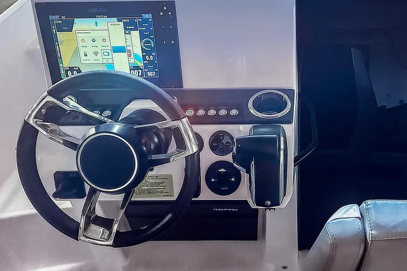 Slide: The Image of 2023 Axopar 25 Cross Top helm with steering wheel and navigation display. - 5