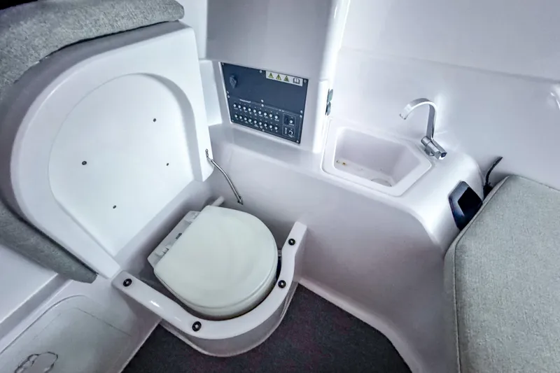 Slide: The Image of 2023 Axopar 25 Cross Top boat interior with compact toilet and sink area. - 7