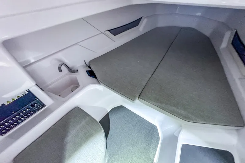 Slide: The Image of 2023 Axopar 25 Cross Top cabin interior with cushioned seating and compact sink. - 8