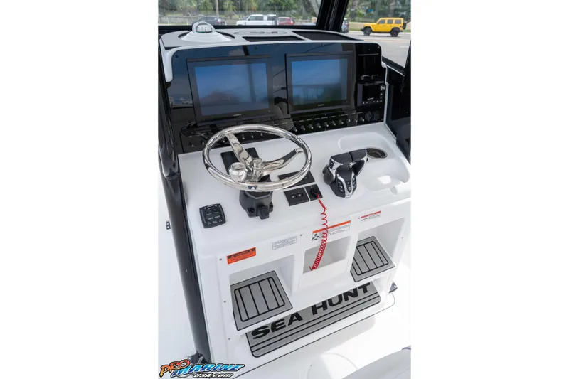 Slide: The Image of 2026 Sea Hunt Gamefish 27 Coffin Box helm with dual screens and steering wheel. - 19