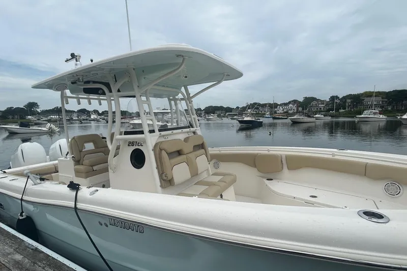 Slide: The Image of 2020 Key West Billistic 261 Center Console boat docked in a serene marina. - 2