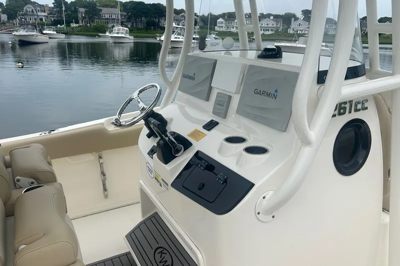 Slide: The Image of 2020 Key West Billistic 261 Center Console boat with Garmin navigation, docked in a scenic harbor. - 6