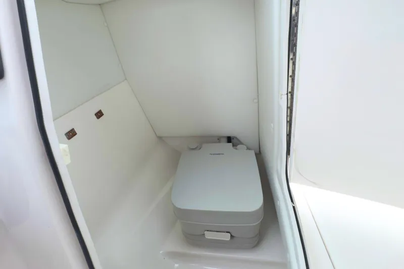 Slide: The Image of 2022 Regal 23 OBX boat interior with compact marine toilet. - 18