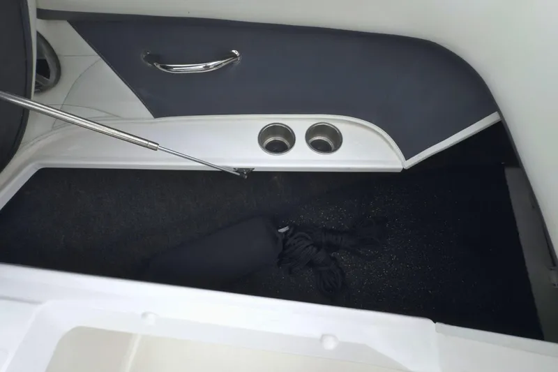 Slide: The Image of Interior of 2022 Regal 23 OBX boat showing storage compartment and cup holders. - 32