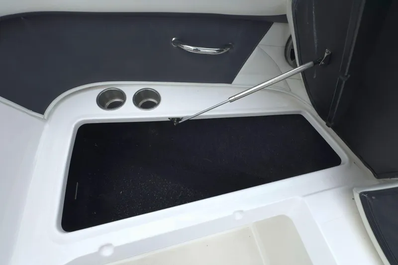 Slide: The Image of 2022 Regal 23 OBX boat storage compartment with cup holders and hydraulic lift. - 33