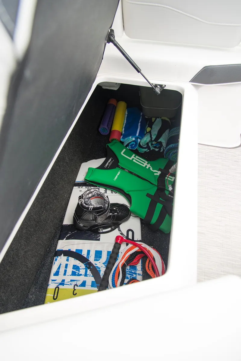 Slide: The Image of 2022 Regal 23 OBX boat cruising on a calm lake with trees in the background. - 5