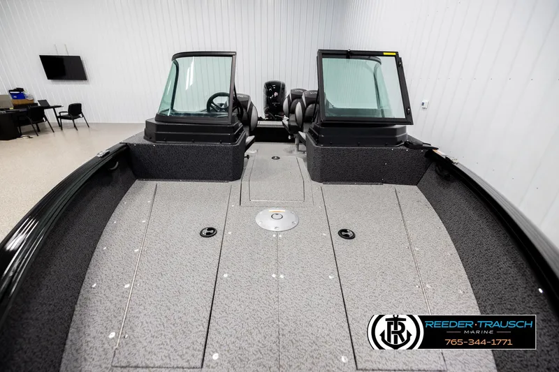 Slide: The Image of 2026 Lund 1800 Explorer Sport boat interior in showroom, featuring dual consoles and spacious deck. - 14