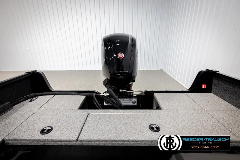 Slide: The Image of 2026 Lund 1800 Explorer Sport boat interior with motor, displayed in showroom. - 16