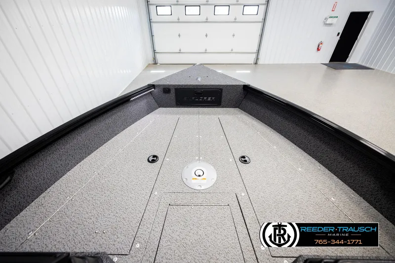 Slide: The Image of 2026 Lund 1800 Explorer Sport boat interior in a showroom, featuring a spacious deck. - 18