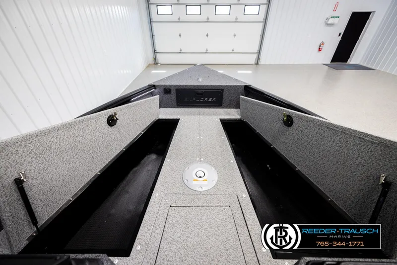 Slide: The Image of 2026 Lund 1800 Explorer Sport boat interior with open storage compartments in a showroom. - 19