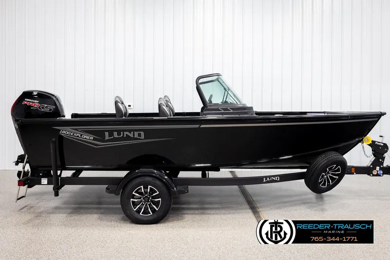 Slide: The Image of 2026 Lund 1800 Explorer Sport boat on trailer, black exterior, displayed indoors. - 3