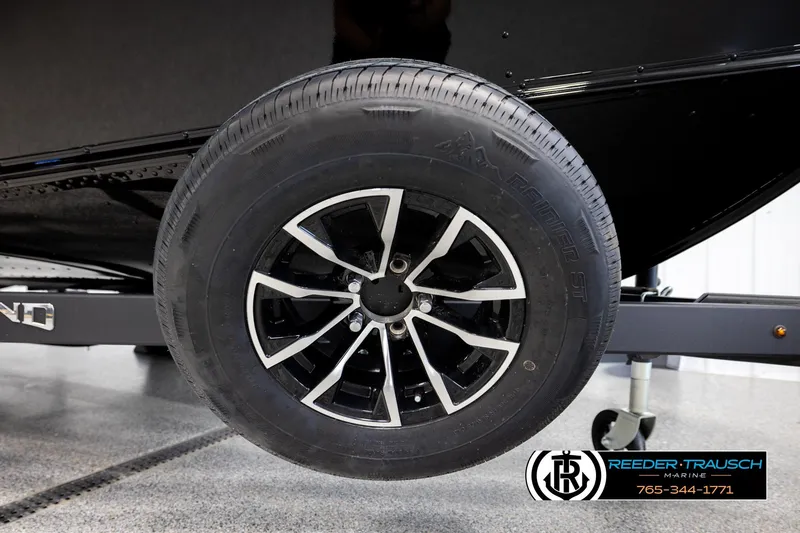 Slide: The Image of 2026 Lund 1800 Explorer Sport trailer wheel, black alloy rim, Reeder-Trausch Marine logo. - 44