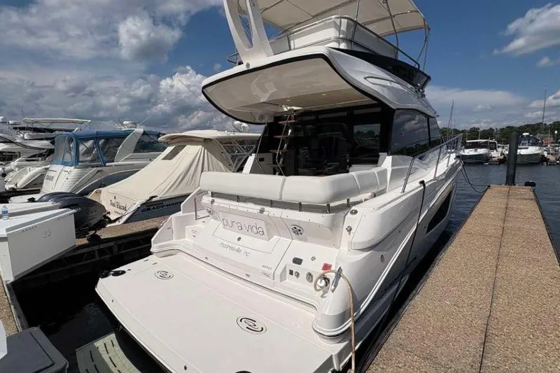 Slide: The Image of 2019 Regal 42 Fly yacht docked at marina under a partly cloudy sky. - 3