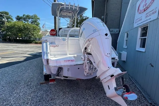 The Image of 2026 Robalo R230 Center Console boat with powerful outboard motor, parked on gravel. - 0