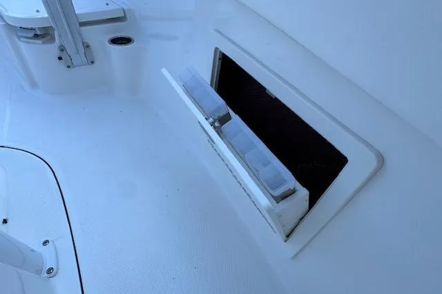 Slide: The Image of 2026 Robalo R230 Center Console boat storage compartment with tackle boxes. - 12