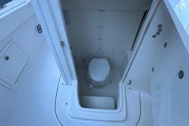 Slide: The Image of 2026 Robalo R230 Center Console boat interior with compact marine toilet. - 17