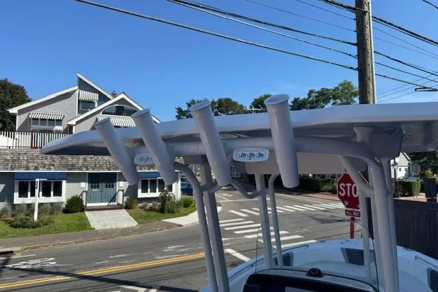 Slide: The Image of 2026 Robalo R230 Center Console boat with rod holders, parked near residential street. - 20