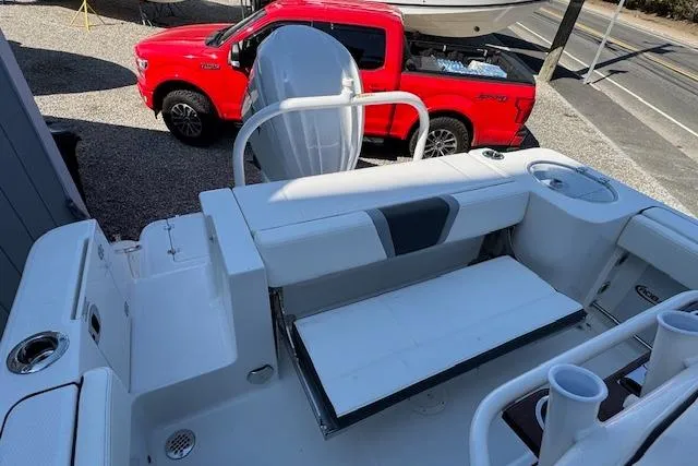 Slide: The Image of 2026 Robalo R230 Center Console boat interior with seating, near a red truck. - 8