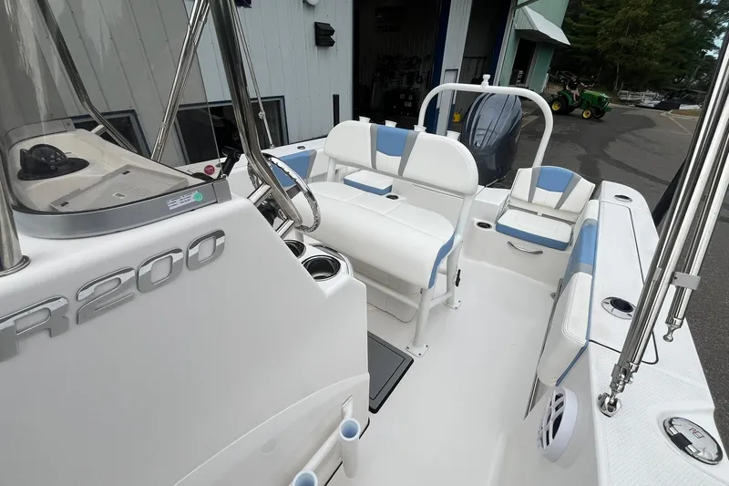 Slide: The Image of 2023 Robalo R200 Center Console boat interior with white and blue seating. - 34