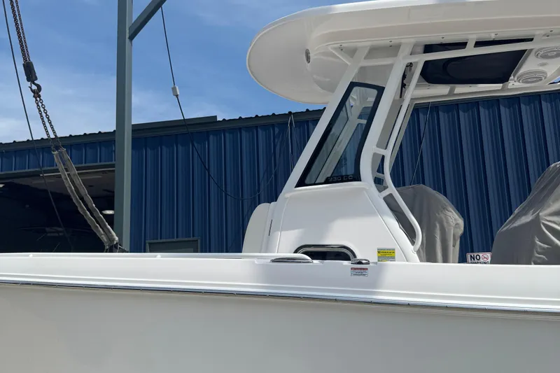 Slide: The Image of Edgewater 230CC 2026 boat with sleek design, docked near blue building. - 21