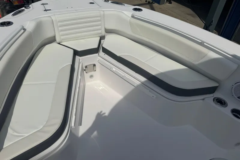 Slide: The Image of 2026 Edgewater 230CC boat interior with white cushioned seating and cup holders. - 23