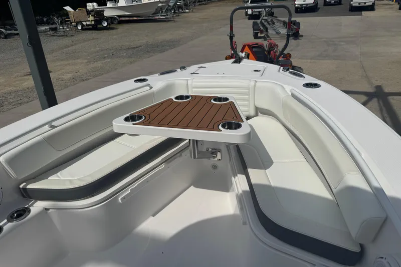 Slide: The Image of 2026 Edgewater 230CC boat interior with cushioned seating and wooden table. - 25