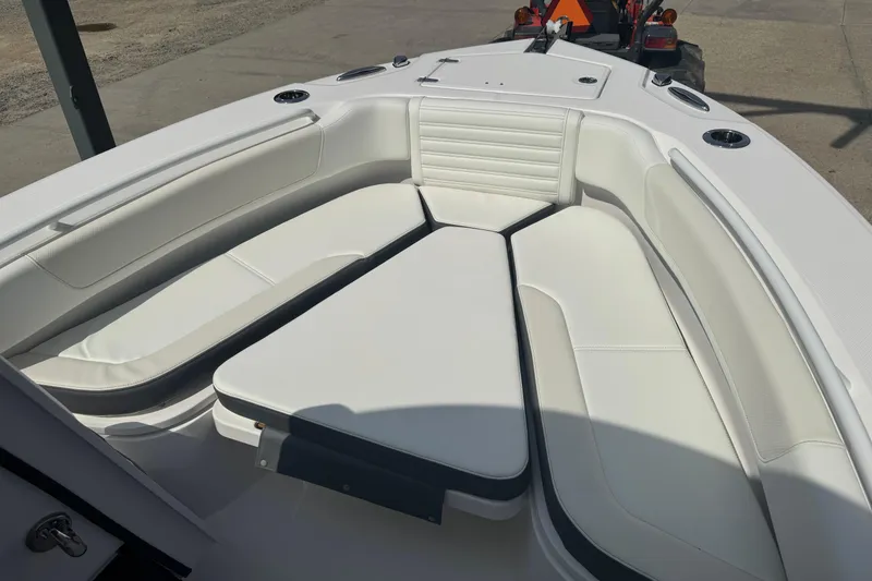 Slide: The Image of 2026 Edgewater 230CC boat interior with white cushioned seating and cup holders. - 28