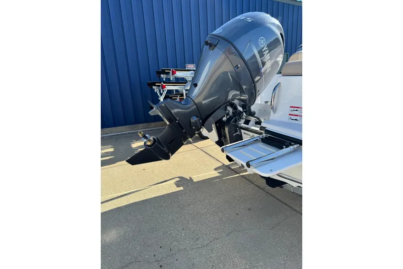 Slide: The Image of 2026 Edgewater 170CC boat with Yamaha outboard motor, parked on concrete near blue wall. - 10