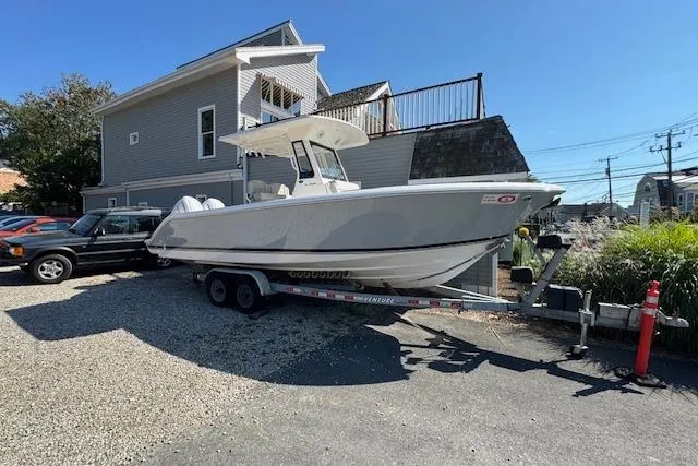 The Image of 2026 Pursuit S 268 Sport boat on trailer, parked near a house. - 0