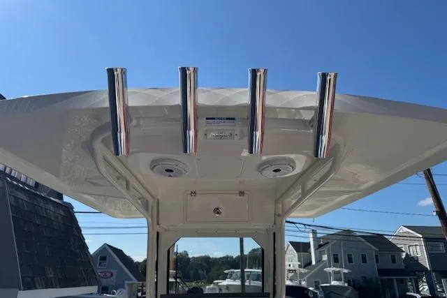 Slide: The Image of 2026 Pursuit S 268 Sport boat with rod holders and speakers under a clear blue sky. - 12