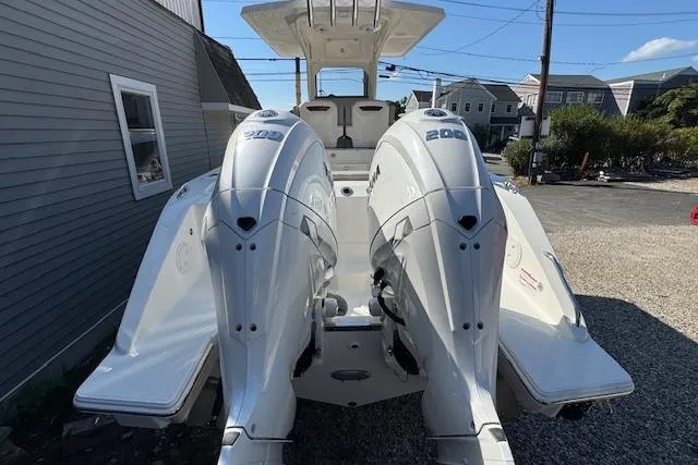 Slide: The Image of 2026 Pursuit S 268 Sport boat with dual 200 horsepower engines, parked outdoors. - 18