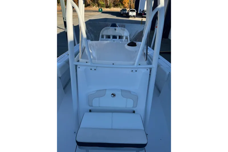Slide: The Image of 2026 Edgewater 208CC boat interior with seating and console, parked outdoors. - 12